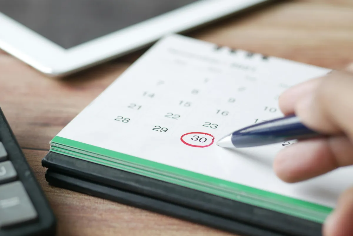 Kalender auf einem Schreibtisch mit einem rot umkreisten Datum
