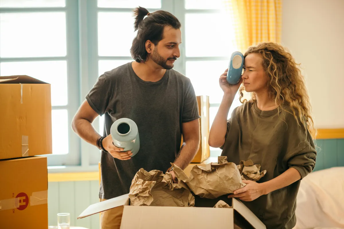 Couple unpacking boxes together in a new apartment