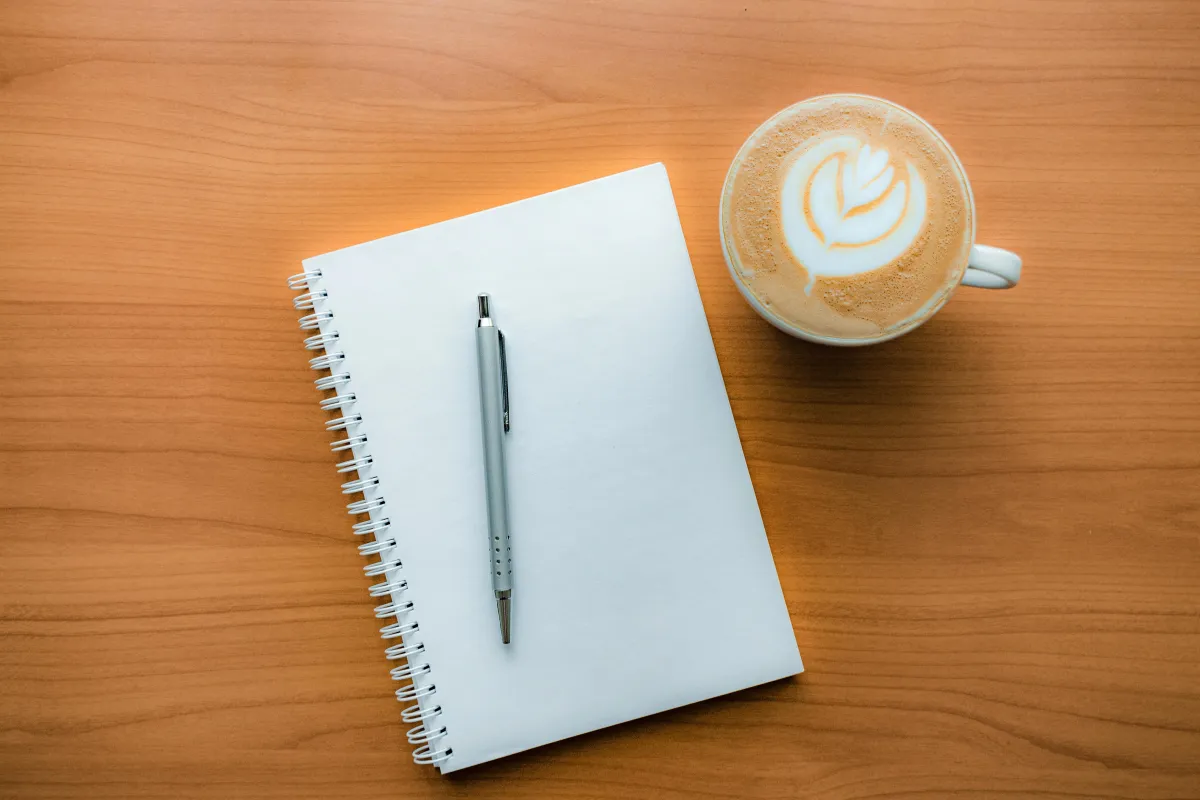Journal and coffee on a table with warm morning light