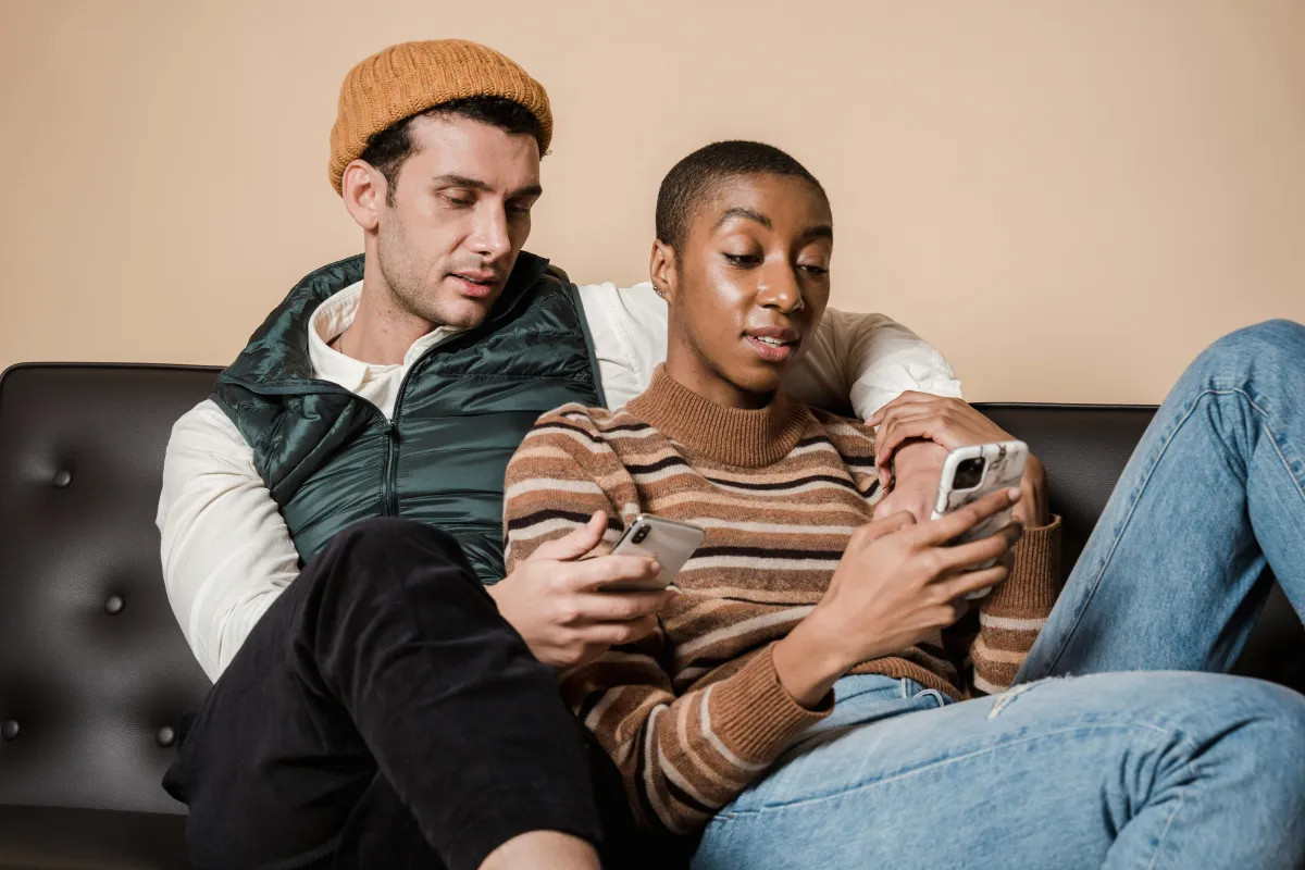 Couple assis ensemble en faisant défiler des souvenirs partagés sur un téléphone